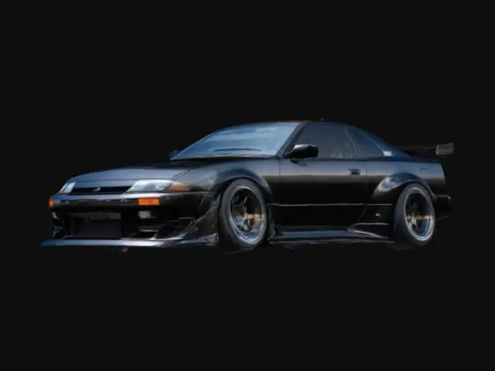 3D model for Widebody 1991 Nissan 240SX (S13) with aggressively flared fenders, lowered stance, deep-dish multi-spoke wheels, and a prominent front splitter. Custom aerodynamic side skirts and a ducktail spoiler enhance its stance. Matte black body with carbon fiber accents on the splitter and skirts. Detailed headlights, vented hood, and subtle rivets on the fender flares. Clean, PBR-optimized surfaces for realistic reflections and shading