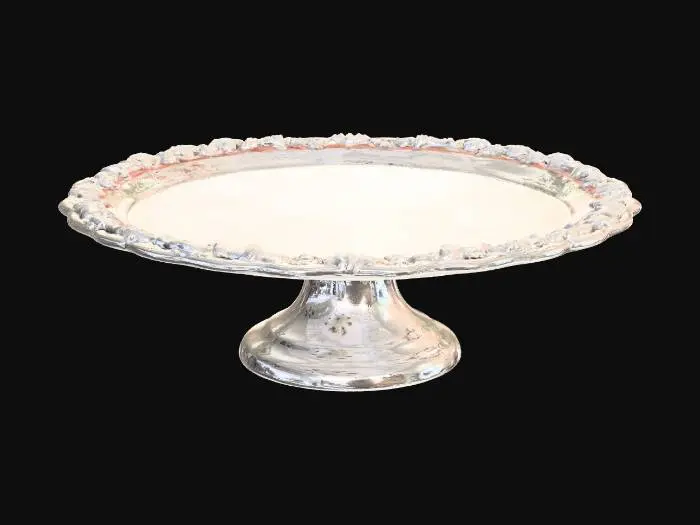 3D model for A classic European pedestal cake stand, white ceramic material, thick round plate with a slightly raised rim, delicate embossed floral and scroll patterns around the edge, smooth and clean plate surface, short and sturdy pedestal base with matching ornamental relief details, elegant and balanced proportions, French patisserie display style, fine glazed porcelain texture with soft reflections, pristine and flawless, single object, centered composition, isolated on pure black background, professional studio lighting, realistic shadows, photorealistic, ultra-detailed, 8K, commercial product photography