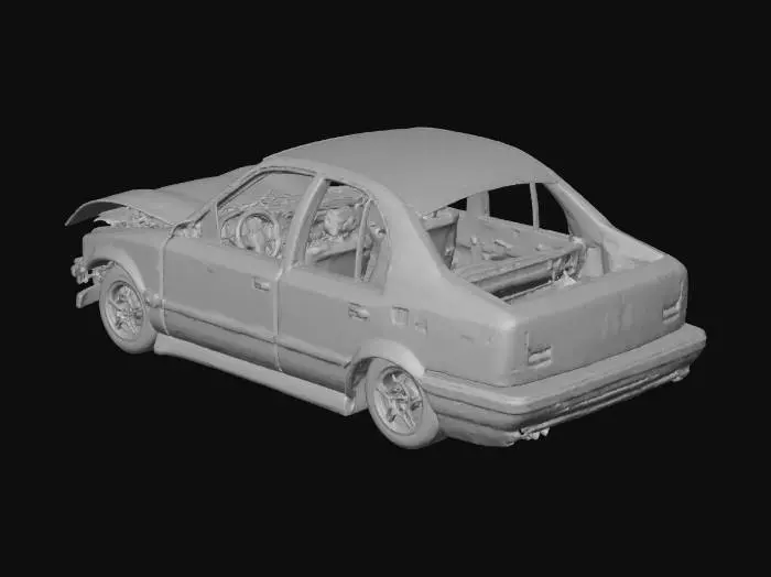 3D model for A heavily charred car wreck, its metallic frame twisted and contorted, revealing exposed structural beams. The blackened surface is covered in thick soot and ash, with remnants of melted plastic adhering to the warped chassis. Sections of glass are shattered, and tires are completely incinerated, leaving a desolate, gritty texture. The overall shape is collapsed and misshapen, conveying immense damage.