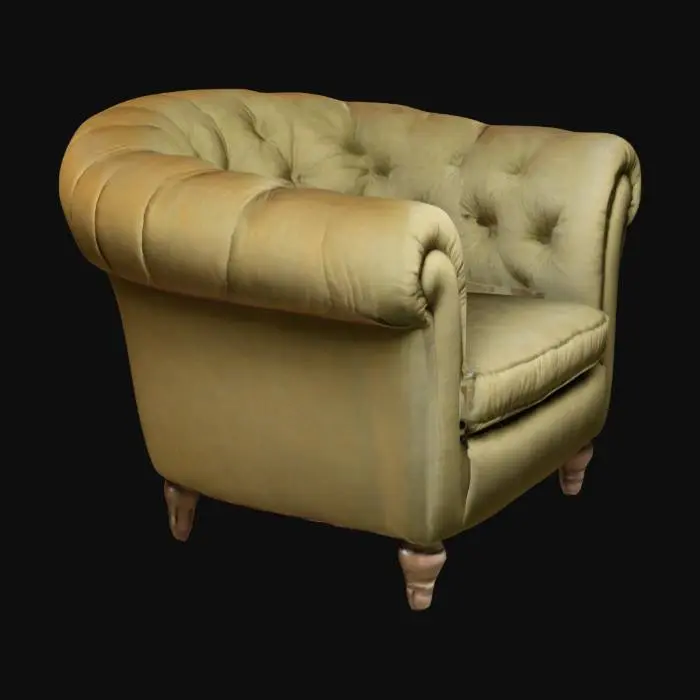 3D model for A vintage-style armchair with a plush, overstuffed design. The chair has a rounded backrest, deep cushioning, and large, curved armrests. The upholstery is soft fabric with visible folds and creases, giving it a cozy, worn-in look. The legs of the chair are short and slightly hidden under the padding. The color is a muted blue with subtle variations in shading to enhance realism. The chair is set in a warm, softly lit environment, emphasizing comfort and relaxation.