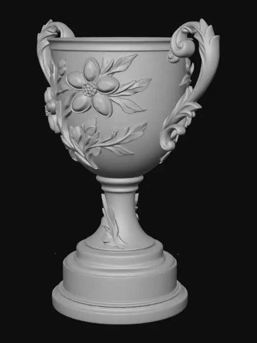3D model for Visual Description of the Luxury Trophy
This image features a stunning, high-end trophy that combines classical goldsmithing with fine jewelry techniques.

Structure and Materials
The Body: A chalice-style cup made of polished yellow gold with a mirror-like finish.

The Handles: Two ornate, baroque-style handles sweep out from the sides, intricately carved with acanthus leaf motifs.

The Base: The gold stem rests upon a multi-tiered, jet-black cylindrical pedestal (likely onyx or polished lacquer), providing a sharp, sophisticated contrast to the gold.

Gemstone Details
The most striking feature is the floral arrangement "climbing" the front of the cup:

Emerald Petals: Two large flowers are set with vibrant, deep green emeralds cut in pear shapes.

Diamond Centers: The heart of each flowe