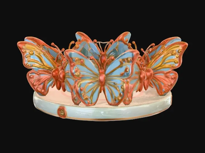 3D model for Three identical, beautifully colored ceramic butterflies, embossed and evenly spaced, and equal height stand wing to wing forming a circular stand on a round ceramic base. Vibrant, detailed, and intricate design reminiscent of the ornate designs of Alphonse Mucha and William Morris