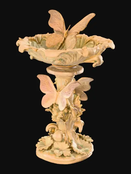 3D model for A pedestal comprised of three butterflies that are holding a bowl shapped base above their wings. The complete design is on a 3 inch round base. Victorian, Extravagant, elaborately embossed design. A masterpiece of art nouveau, lush botanicals are interwoven into the design