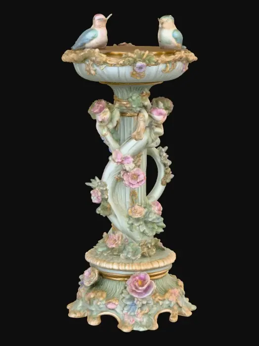 3D model for An elaborately designed pestal with a small bowl shapped base on top. The pedestal sits on a 3 inch base plate. The entire design is a masterpiece of art comprised of lush botanical, florals, cherubs and birds. Elements of Rocco, art nuevo era. Colors representing the victorian era.