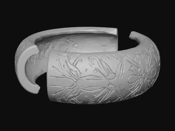 3D model for A crisp, high-fidelity 8K render of an oval bracelet split into two halves, floating in air against a blank neutral background. Each half features interlocking finger joints—three perfectly aligned rectangular teeth with sharp edges and precise symmetry. The surface is finished with deep, debossed floral engravings of Nancy-cherry and mango blooms, rendered in true botanical accuracy: recognizable petals, layered curvature, visible stamens, and delicate leaf veins recessed cleanly into the surface. The design is minimal, elegant, and flawlessly finished; the deboss depth creates sharp shadow lines and crisp texture, while soft, even lighting accentuates the floral detail and the refined geometry of the interlocking joints.