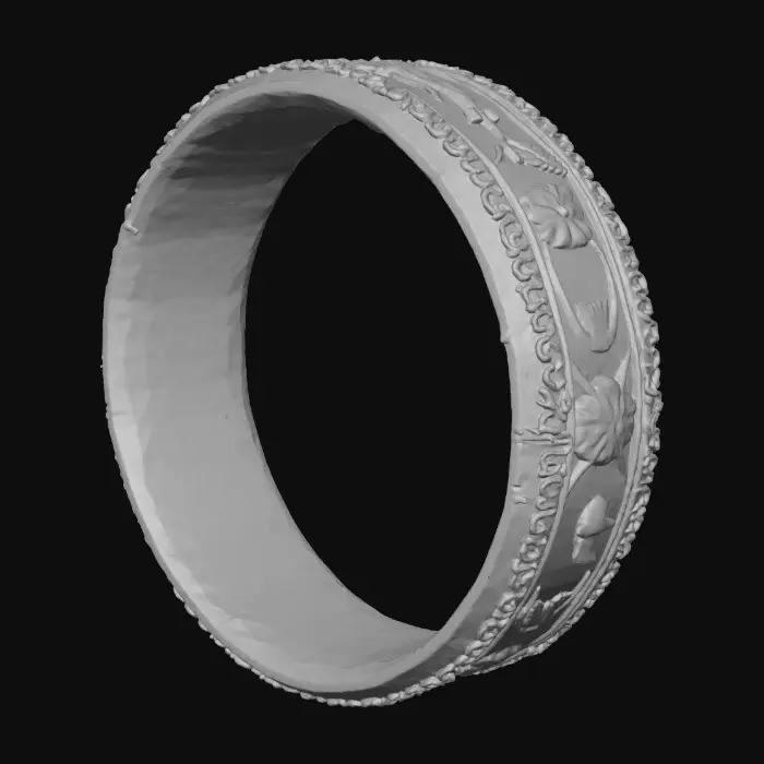 3D model for An ultra-realistic 8K render of a forged oval brass anklet, 5 mm wide and 3 mm thick, shaped perfectly to rest above the ankle bone. The metal glows warm honey-gold with green undertones, mirror-polished on edges and satin-matte in carved areas. On the left side, a seamless hinge with interlocking knuckles; on the right, a locking pin made from 1 mm brass wire threaded through a small hole, wrapped three tight coils around the band, and silver-soldered flush on the outside. The outer surface shows deep debossed Nancy-cherry and mango-bloom motifs, petals and stems intertwining with crisp detail; the inner face bears subtle root-like engravings. Soft diffused light reveals fine texture, shadow depth, and lifelike metallic reflections.