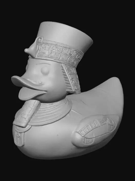 3D model for A Pharaoh rubber duck, solid 3D model. Classic rounded duck body adorned with an ancient Egyptian Nemes headdress, bold and stylized for printing. A sculpted ceremonial beard extends from the beak. Wings decorated with carved hieroglyphic patterns and ankhs in embossed relief. A staff and crook crossed across the chest, chunky and durable. Surface detailed with simple geometric engraving for texture. Watertight geometry, bold forms, and no fragile thin parts