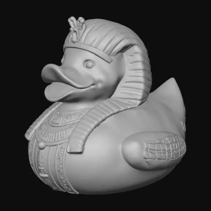 3D model for A Pharaoh rubber duck, solid 3D model. Classic rounded duck body adorned with an ancient Egyptian Nemes headdress, bold and stylized for printing. A sculpted ceremonial beard extends from the beak. Wings decorated with carved hieroglyphic patterns and ankhs in embossed relief. A staff and crook crossed across the chest, chunky and durable. Surface detailed with simple geometric engraving for texture. Watertight geometry, bold forms, and no fragile thin parts