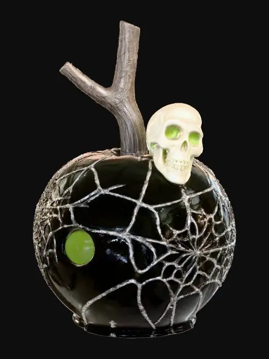 3D model for A "Crypt Keeper's Caramel Apple": A crisp green apple is thickly coated in a dark, almost black, glossy caramel, resembling a polished tombstone. It's impaled on a sturdy stick, and intricate, silver edible sugar dust is painted on the surface to create creepy, yet elegant, spiderweb patterns. A single, small, edible white chocolate skull or bone is affixed to the side. The texture is crunchy apple, sticky caramel, and delicate sugar.