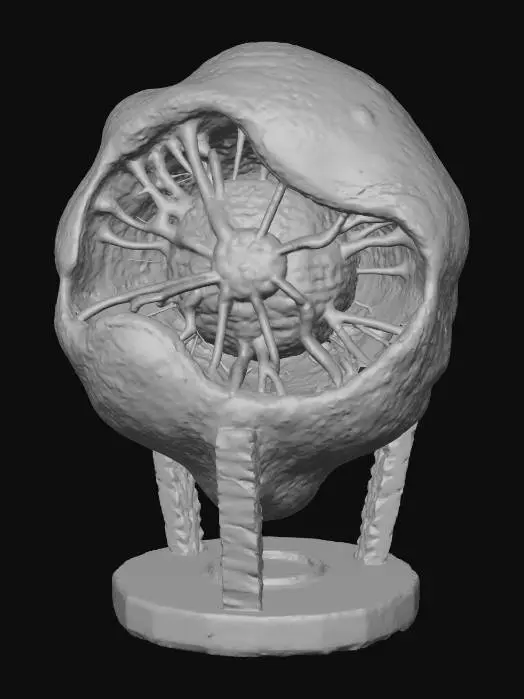 3D model for A **capture point device/beacon** shaped like a glowing, pulsating spore sac. Its outer shell is a semi-transparent, flexible silicone material in neon yellow, revealing an intricate internal structure of rigid, iridescent plastic veins. A core of vibrant, pulsating translucent gel is visible, anchored by a brushed metallic base with carbon fiber textured supports.