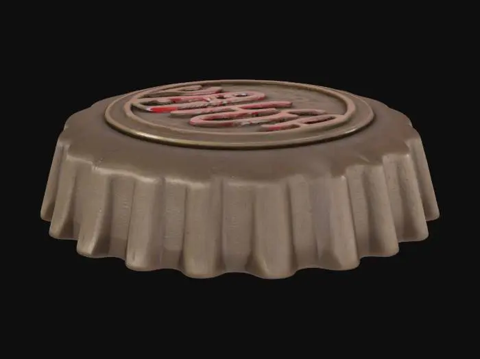 3D model for Create a 3D printable, symmetrical Nuka Cola bottle cap. It should have a realistic, slightly worn metallic texture, with raised ridges around the edge like a classic soda cap. The Nuka Cola logo should be embossed on the top surface in a clear, retro style. Ensure the model is optimized for 3D printing, with no thin or fragile parts
