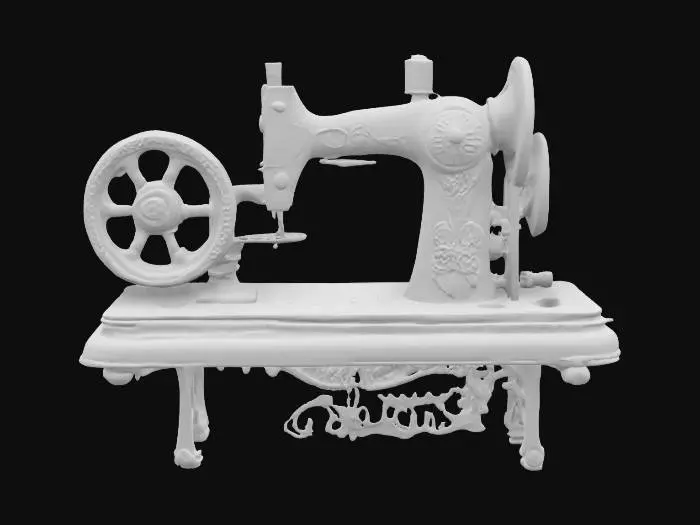 3D model for An antique sewing machine with a large, hand-operated wheel on the side for manual operation. The machine is mounted on a sturdy wooden table with elegant carvings, combining functionality and vintage charm. Its cast iron frame features intricate patterns, while the long, narrow sewing arm extends outward, ending in a precise needle mechanism. The design reflects the craftsmanship of a bygone era, blending utility with timeless elegance