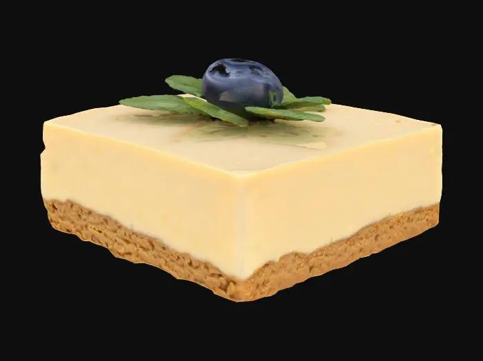 3D model for A tiny square of creamy cheesecake with a smooth, pale ivory surface and subtle sheen. The crust is visible at the base—a coarse, crumbly graham cracker texture in golden brown. A single fresh blueberry and a tiny mint leaf sit atop, both with natural gloss and fine surface detail.