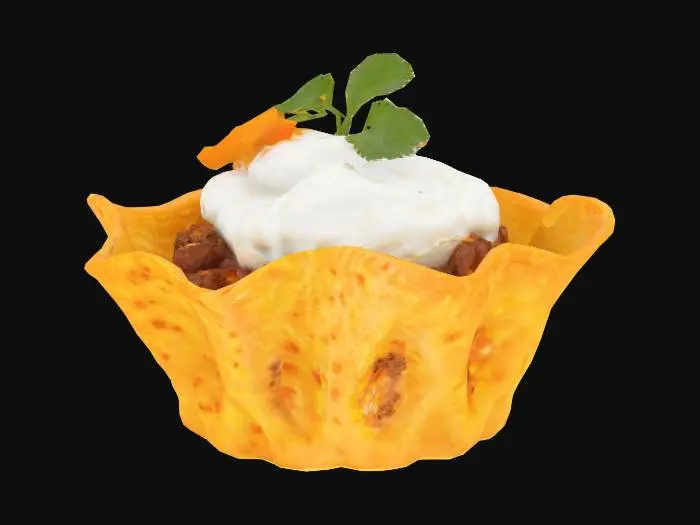 3D model for A bite-sized taco shell molded into a cup, golden and crisp with bubbled surface texture and curled edges. Filled with seasoned ground beef (dark brown, crumbly) and topped with shredded cheddar (vivid orange strands), a dot of sour cream (smooth white peak), and a mini cilantro leaf.