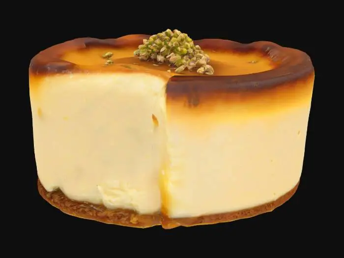3D model for A mini Basque-style burnt cheesecake made with creamy cheese and teff flour—rich golden edges with a soft center. Topped with a glossy drizzle of acacia honey and a pinch of crushed fenugreek seeds for a savory touch.
