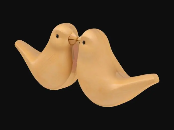 3D model for Generate a 3D model of two carved wooden lovebirds resting side by side. The birds should be small, rounded, and slightly abstract, with their heads gently tilted toward each other. Use light-colored wood such as maple or beech, with a matte or lightly polished finish. Display on a floating shelf with warm natural lighting and a soft background.