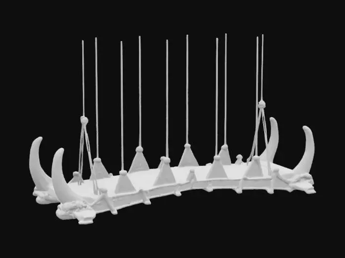 3D model for ancient bridge made of animal bone and rope suspended from even larger animal bone. The bone steps for the bridge are carved with red and gold hieroglyphics. 