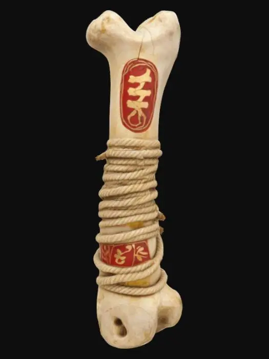 3D model for a large aged animal bone wrapped in ancient rope. Standing tall and carved with red and gold markings. Ultra high resolution. 