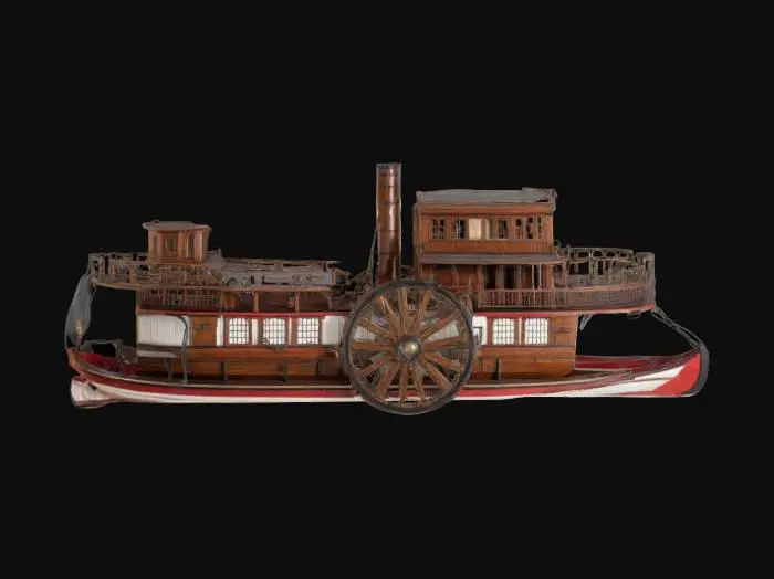 3D model for  a 19th-century paddleboat. Include a large central paddlewheel with visible spokes and intricate wooden and metal detailing. The hull should feature wooden planks and riveted metal edges, with smooth, curved lines. Add features like smokestacks, railings, and a small pilot house with era-appropriate windows and doors. Incorporate decorative trim along the deck and nameplates to reflect period craftsmanship. Textures should highlight wood grain, polished metal, and light wear.











