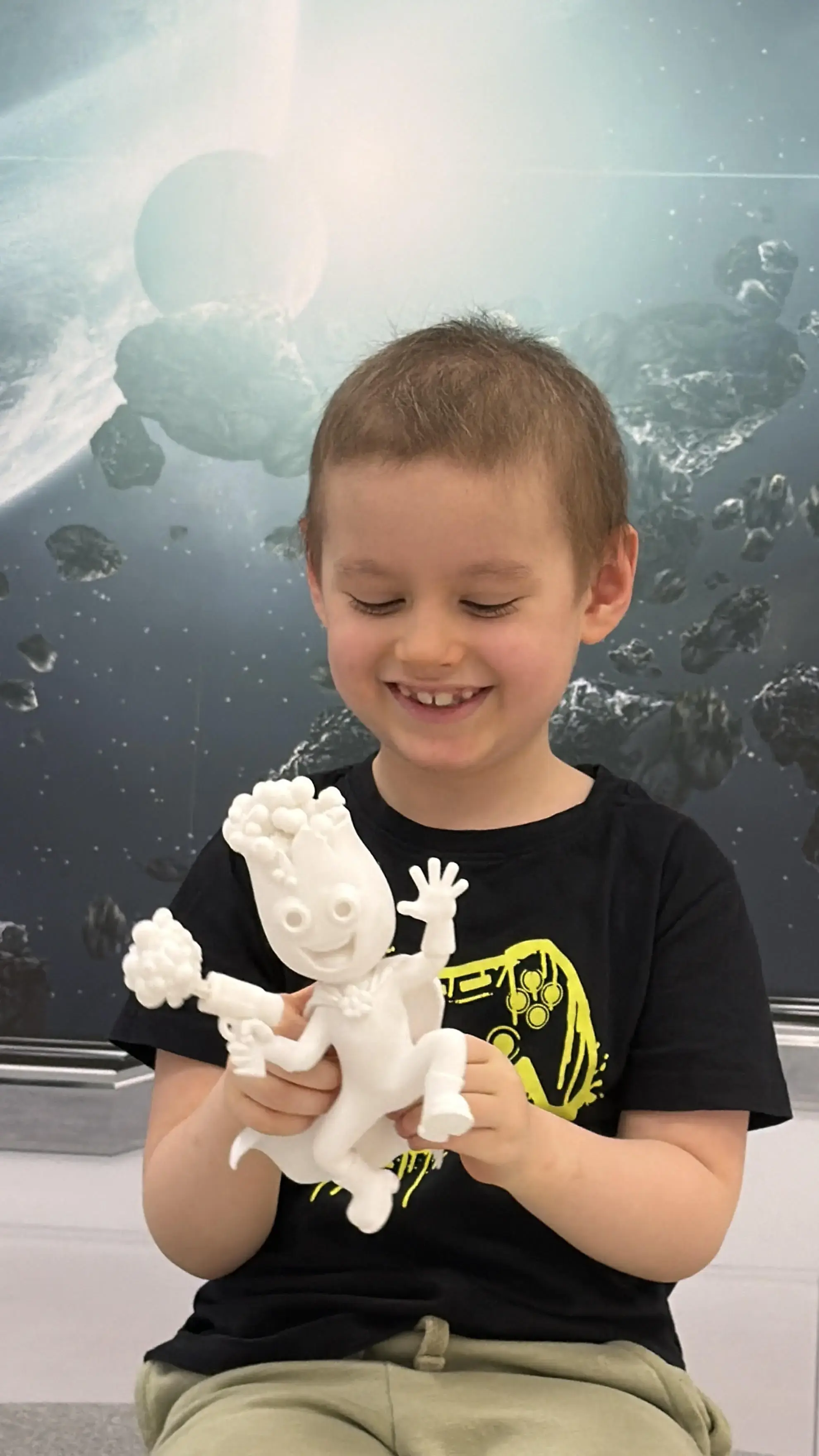 smiling-child-patient-holding-3d-printed-superhero-toy