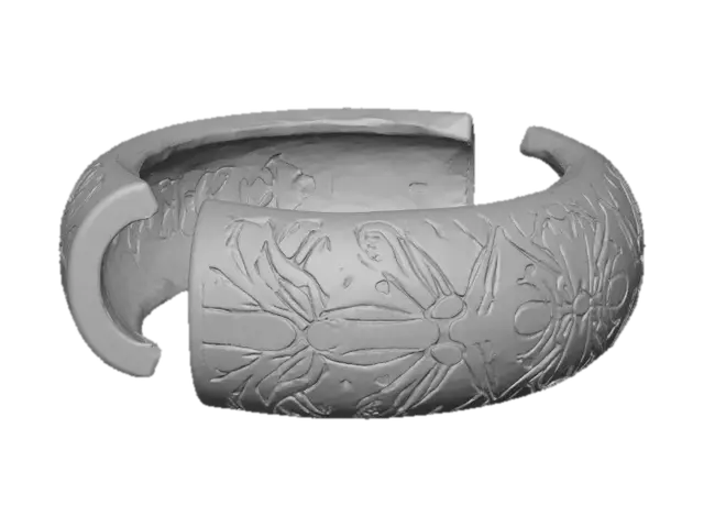 3D model for A crisp, high-fidelity 8K render of an oval bracelet split into two halves, floating in air against a blank neutral background. Each half features interlocking finger joints—three perfectly aligned rectangular teeth with sharp edges and precise symmetry. The surface is finished with deep, debossed floral engravings of Nancy-cherry and mango blooms, rendered in true botanical accuracy: recognizable petals, layered curvature, visible stamens, and delicate leaf veins recessed cleanly into the surface. The design is minimal, elegant, and flawlessly finished; the deboss depth creates sharp shadow lines and crisp texture, while soft, even lighting accentuates the floral detail and the refined geometry of the interlocking joints.