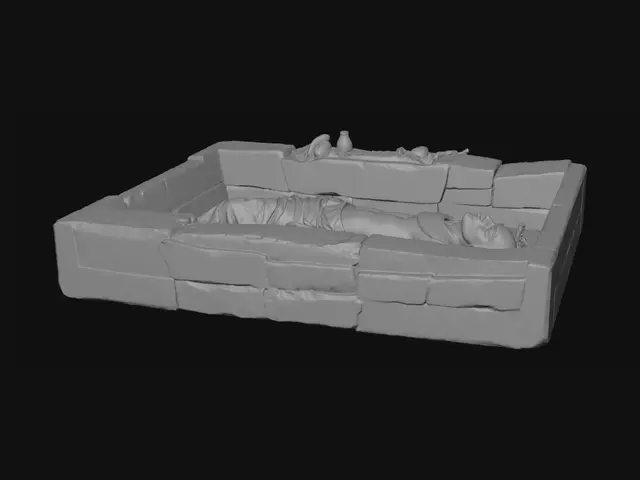 3D model for 3D Egyptian burial diorama shown as a cutaway desert tomb. A linen-wrapped body lies on its back in a shallow stone-lined chamber, with worn bandages revealing darkened preserved skin. Surrounding artefacts include a decorative broad collar necklace, simple bracelets, and a scarab amulet on the chest. Nearby are a small jar, a shabti figure, a broken pottery vessel, and food offerings. Sand layers and stone structure are visible in cross-section. Lighting is warm and soft with sandy tones. Style is realistic but simplified, like a museum display, designed for clear educational viewing and interpretation.