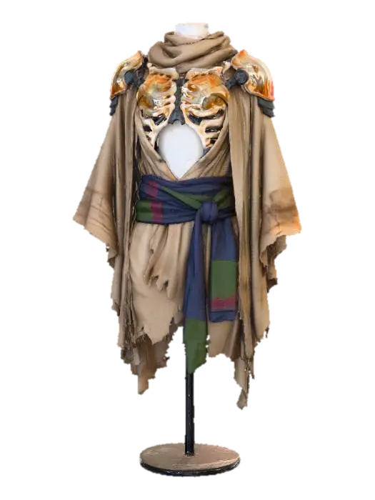 3D model for A layered desert cloak, draped over a torso with exposed bio-art inspired skeletal-tech plating in bone-white and faded ochre, connected by dark pewter joints. Sinuous, organic forms define the armor. A vibrant yet desaturated indigo sash cinches the waist, with subtle crimson and deep olive fabric patches. This ensemble marries natural-tech structure with ritualistic flair and a diverse, low-saturation palette.